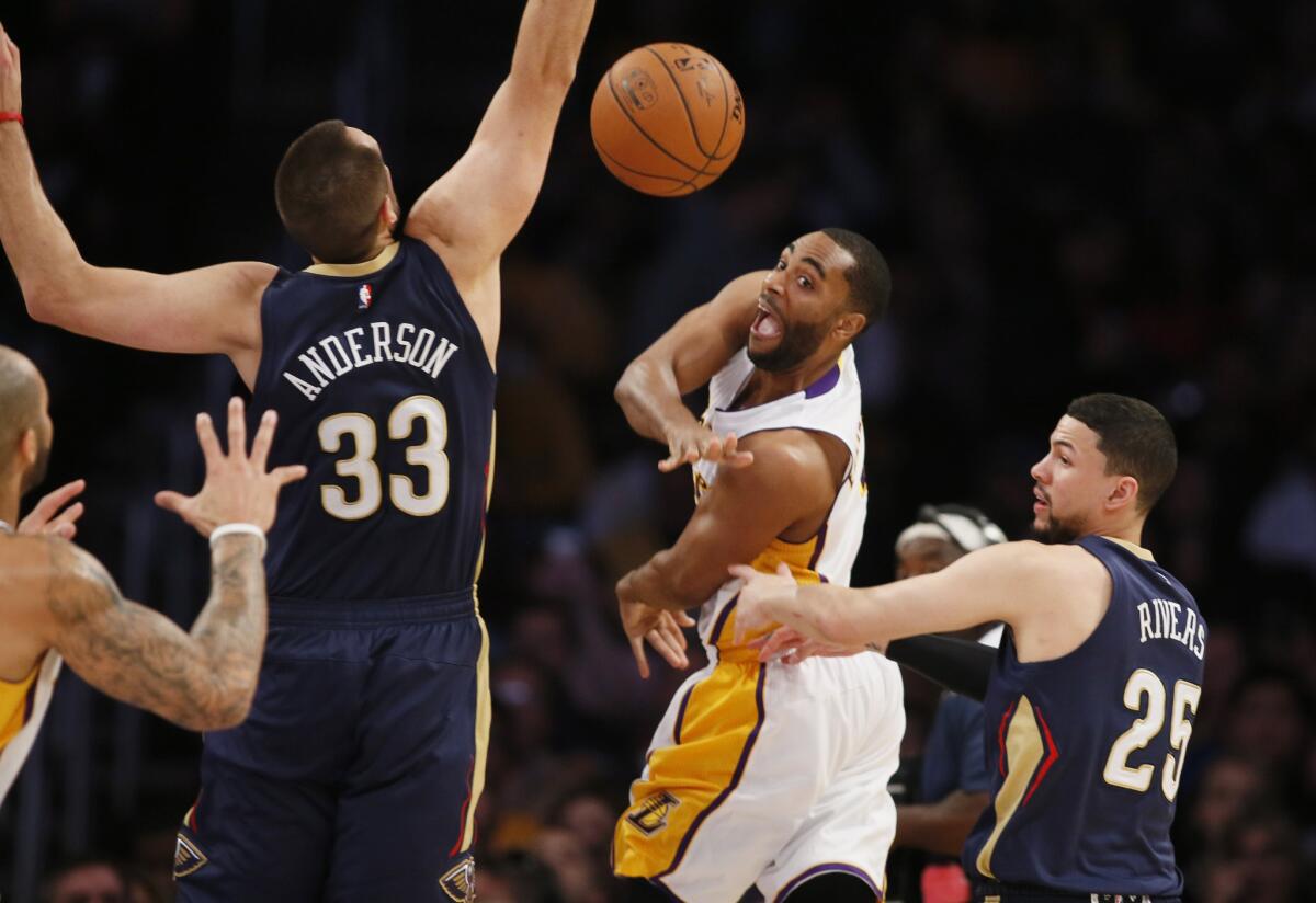Lakers guard Wayne Ellington sends a pass between New Orleans Pelicans forward Ryan Anderson (33) and point guard Austin Rivers, hitting teammate Carlos Boozer during a Dec. 7 game at Staples Center.