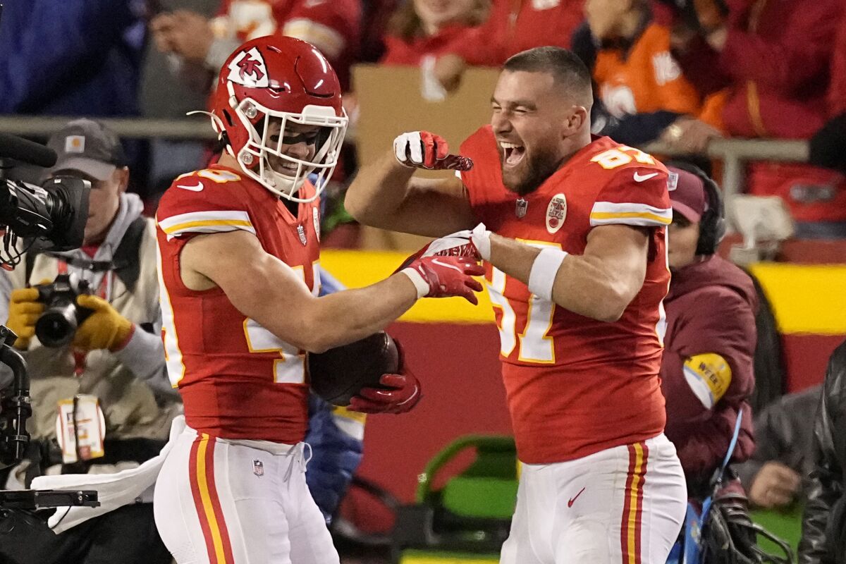 Kansas City Chiefs safety Daniel Sorensen, left, is congratulated by teammate Travis Kelce after intercepting a pass and running it back for a touchdown during the second half of an NFL football game against the Denver Broncos Sunday, Dec. 5, 2021, in Kansas City, Mo. (AP Photo/Charlie Riedel)