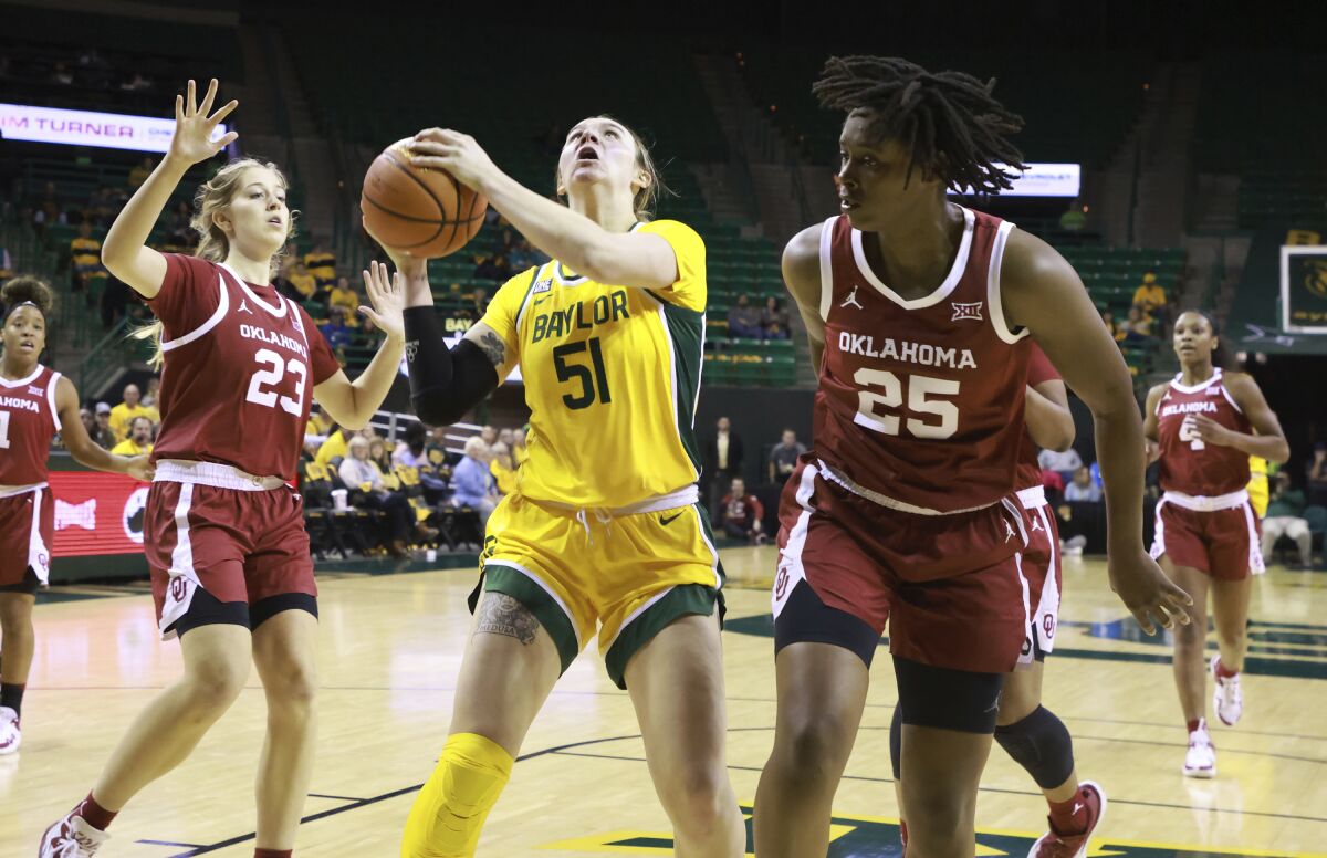 Baylor forward Caitlin Bickle, center, pulls up for a shot between Oklahoma's Kaley Perkins, left, and Madi Williams during the first half of an NCAA college basketball game Wednesday, Feb. 2, 2022, in Waco, Texas. (Rod Aydelotte/Waco Tribune-Herald via AP)