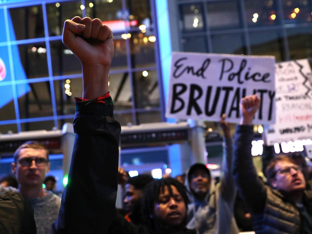 Black Lives Matter protesters hold their fists in the air as they block the entrance to the Golden 1 Center arena during a demonstration in Sacramento.