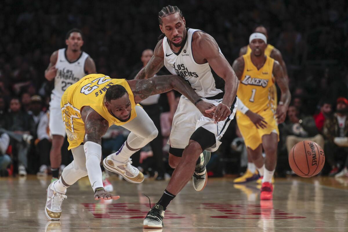 Clippers forward Kawhi Leonard knocks the ball from Lakers forward LeBron James during the fourth quarter of an NBA game Dec. 25.