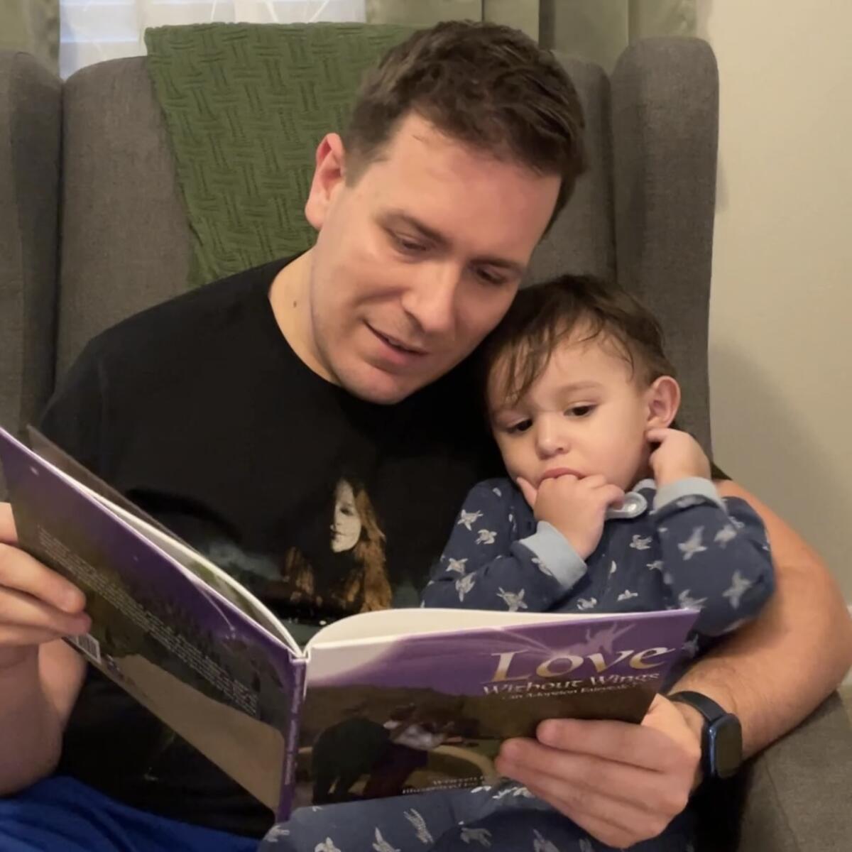 Adam Swain Ferguson reading with his son Taran.