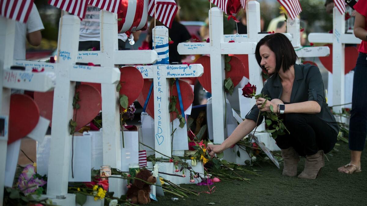 Antoinette Cannon, a trauma nurse who treated victims of the deadly shootings in Las Vegas, leaves a rose at each of the 58 white crosses at a makeshift memorial on the south end of the Strip on Oct. 7.