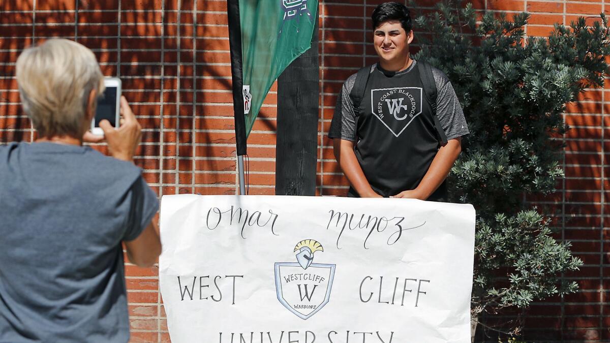 Baseball player Omar Munoz with his banner as he participates in a National Signing Day ceremony at Costa Mesa High School on Wednesday.