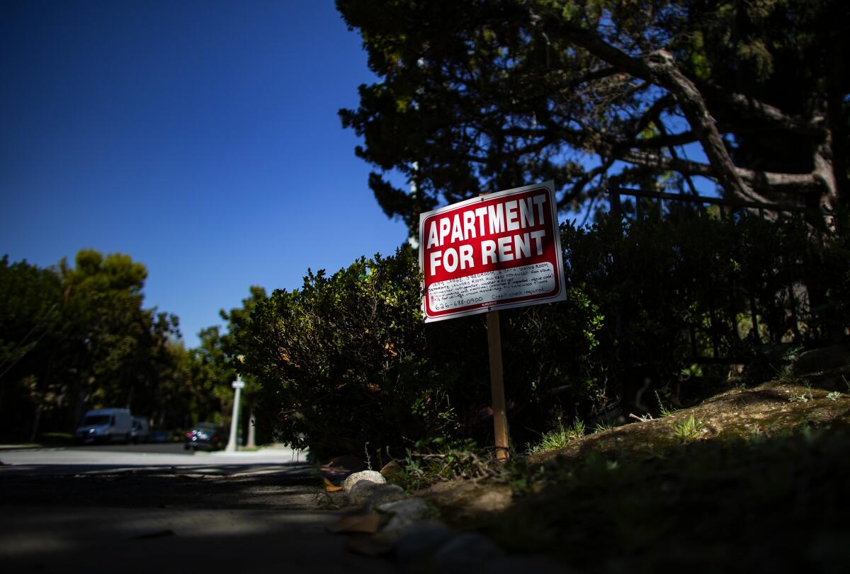 A sign that says "Apartment for rent" posted in a lawn