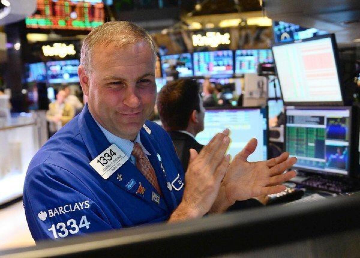Traders react at the end of trading Tuesday at the New York Stock Exchange. The Dow Jones industrial average closed at 14,253.77, a new all-time high. Broader stock indexes have also been hovering near all-time records.