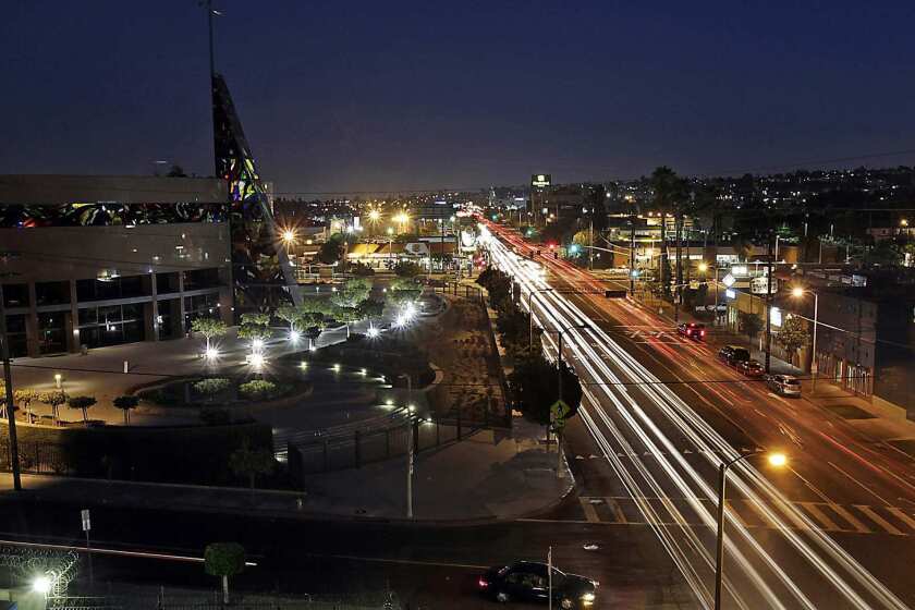 Traffic streams along Crenshaw Boulevard near its intersection with Exposition Boulevard in the Crenshaw district of Los Angeles. The district is about 60% African American. Prominent buildings along this stretch of the boulevard include the West Angeles Cathedral, left, the Baldwin Hills Crenshaw Plaza shopping center and the Angelus Funeral Home, which was designed by noted architect Paul R. Williams.