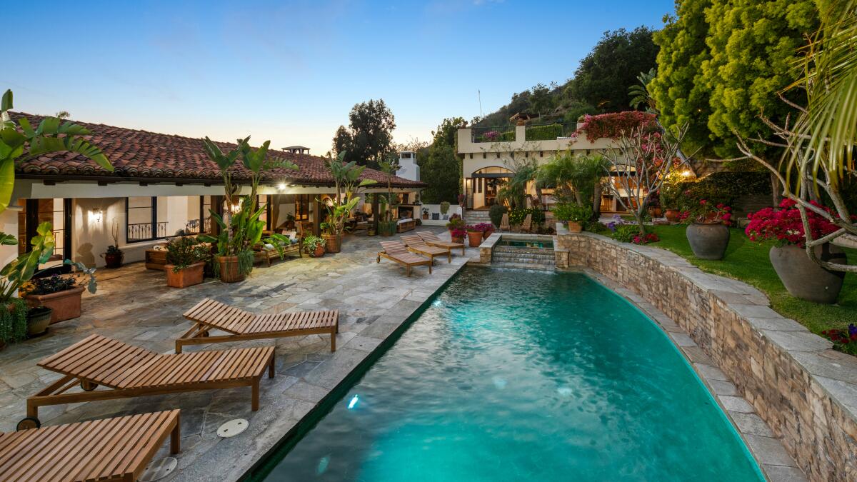 A pool in the big backyard of a compound.
