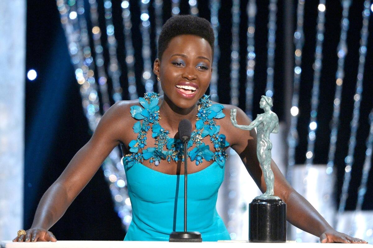 Lupita Nyong'o accepts the honor for female actor in a supporting role at Saturday's SAG Awards. Her blue dress is by Gucci.