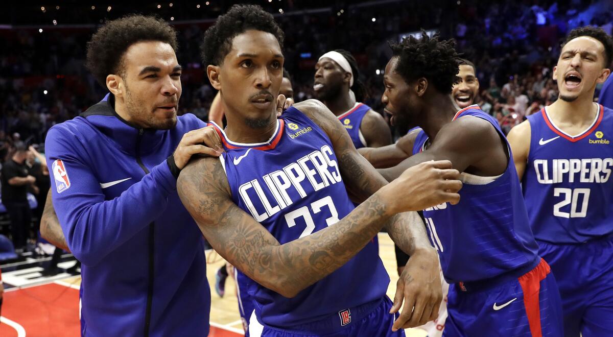 Clippers guard Lou Williams (23) is mobbed by teammates after making the game-winning shot against the Nets on Sunday.