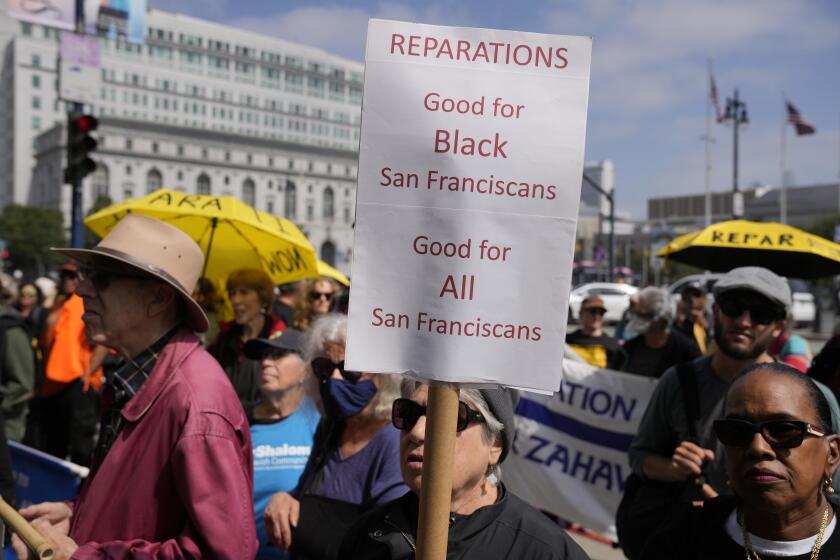 People listen during a rally in support of reparations for African Americans outside City Hall in San Francisco, Tuesday, Sept. 19, 2023. (AP Photo/Eric Risberg)