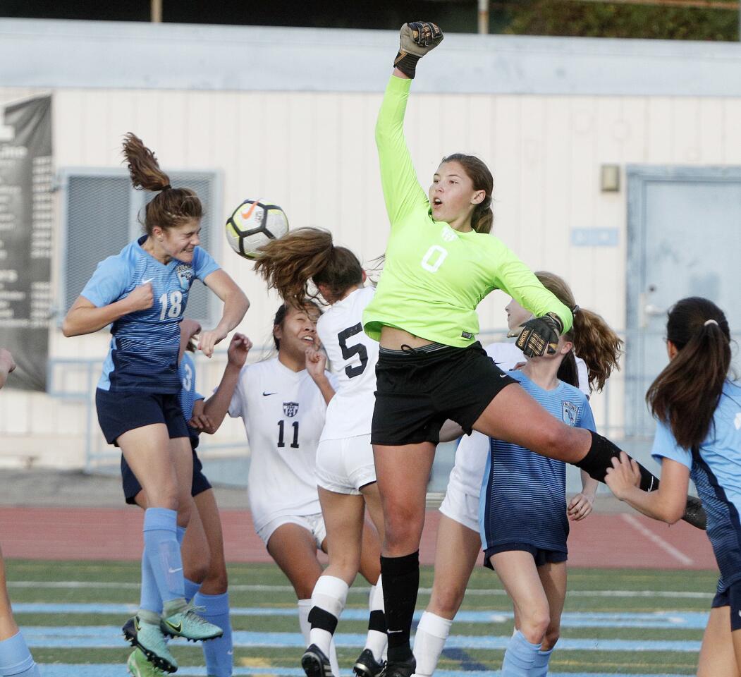 Crescenta Valley's Chloe Ataya heads a corner kicks that just floats over the hands of Flintridge Sacred Heart Academy's goalie Jamie Pernecky in a non-league girls' soccer game at Crescenta Valley High School on Tuesday, November 27, 2018. Crescenta Valley won the game 4-0.