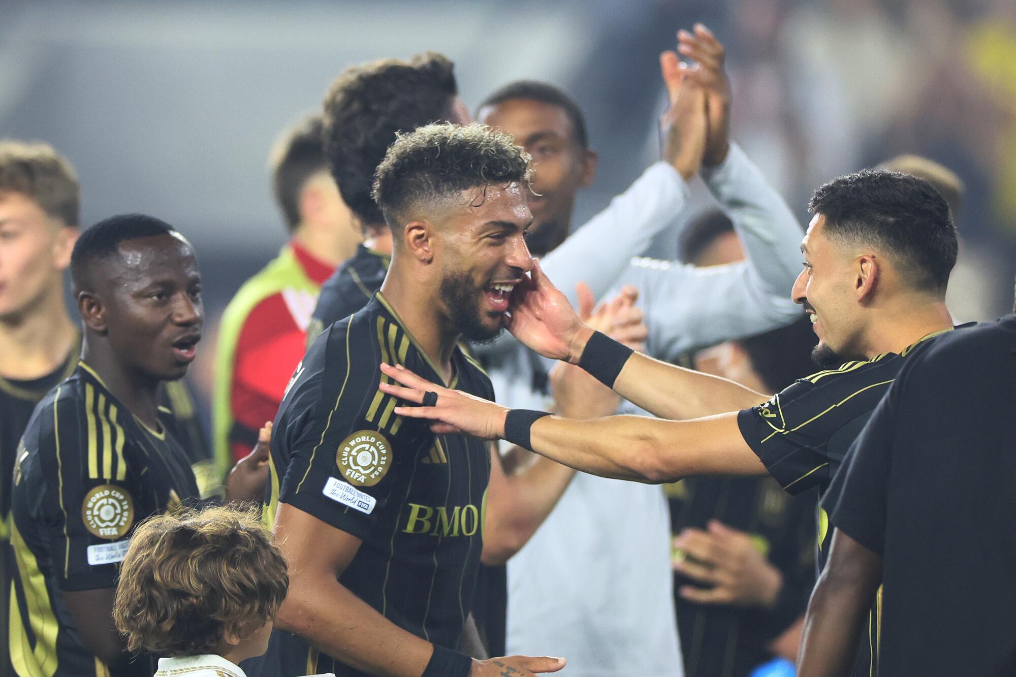 Denis Bouanga reaches to embrace his teammates.