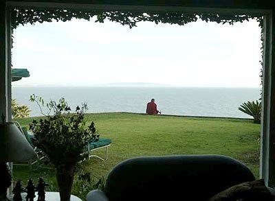 Geshi Tenpa Sonam, visiting from Drepung Gomang Monastery, prays at Kathy Rodman's home overlooking the ocean.