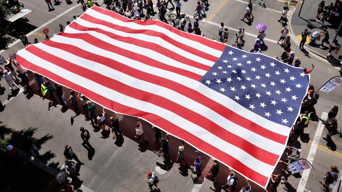 Marchers carry a giant American flag at the start of the May Day march that began at MacArthur Park. (Al Seib / Los Angeles Times)