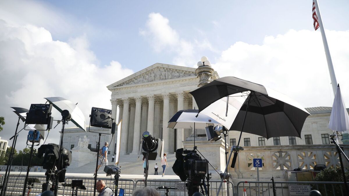 Television camera crews wait outside the Supreme Court in Washington, Tuesday, Oct. 9, 2018.