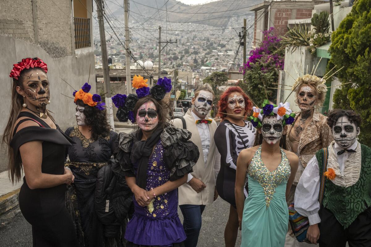 A group of people in face paint and elaborate outfits pose for a photo