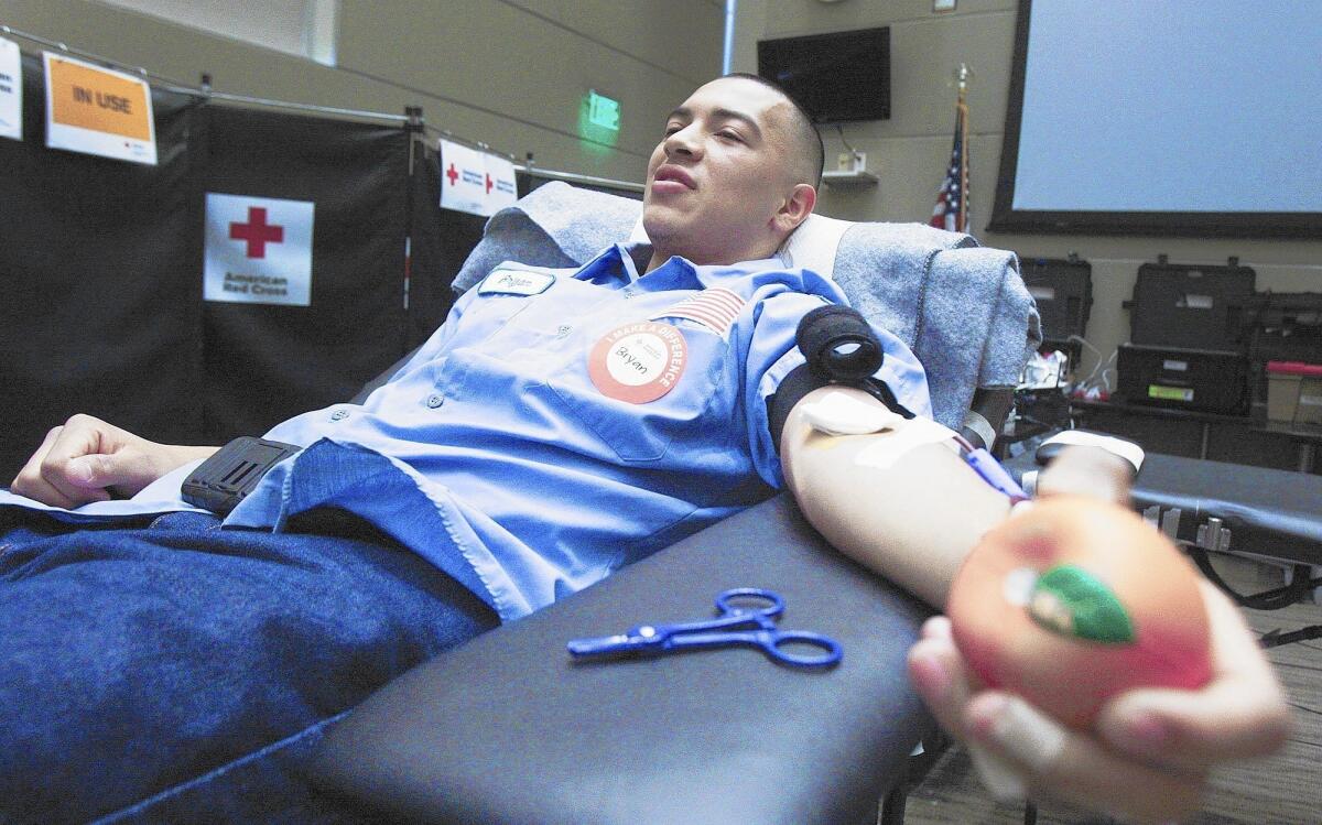 Bryan Gonzalez with Burbank Management Services donates blood at a Red Cross blood drive hosted by Burbank Police and Fire departments on Tuesday, Feb. 18, 2014 at the Burbank Community Services Building in the Community Room in Burbank. He said he saw Burbank police officers donating and thought it was a good idea to give back too.