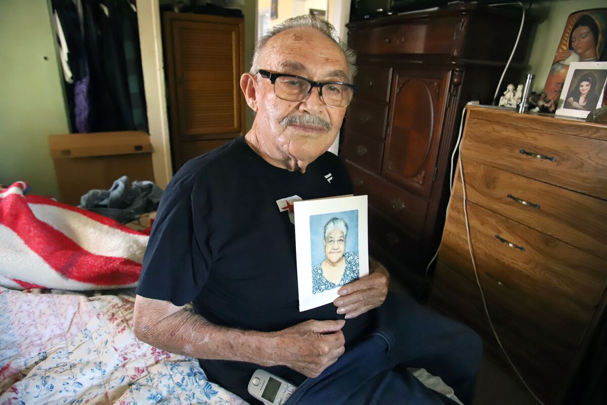 A man holds a photo of a woman