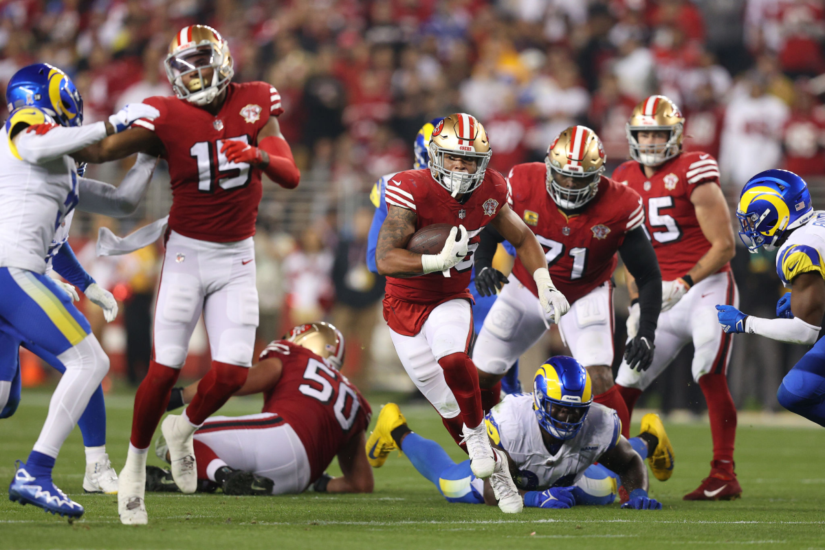 San Francisco 49ers running back Eli Mitchell carries the ball during the first half.