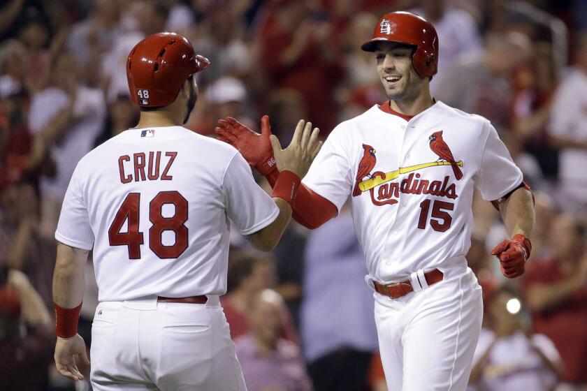 Cardinals center fielder Randal Grichu is congratulated by teammate Tony Cruz after hitting a two-run home run against the Cubs on Tuesday.