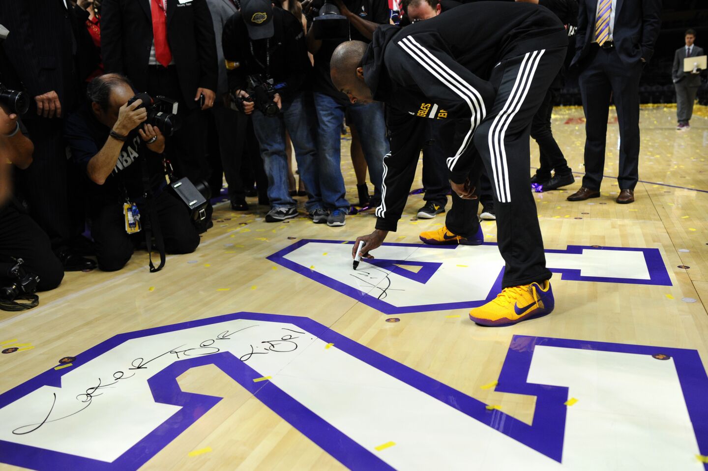 Kobe Bryant signs the court late into the night at the Staples Center.