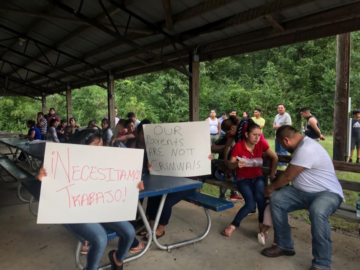Trabajadores de PH Foods y simpatizantes de su causa sostienen carteles que dicen, "¡Necesitamos trabajo!" y "Nuestros padres no son criminales", el martes 13 de agosto del 2019 en Morton, Mississippi, después de que las autoridades migratorias arrestaran a casi 100 trabajadores en esta planta de procesamiento de pollos. (AP Foto/Terry Truett)
