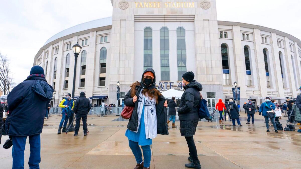 Varias personas hacen fila para vacunarse contra COVID-19 en el Yankee Stadium.