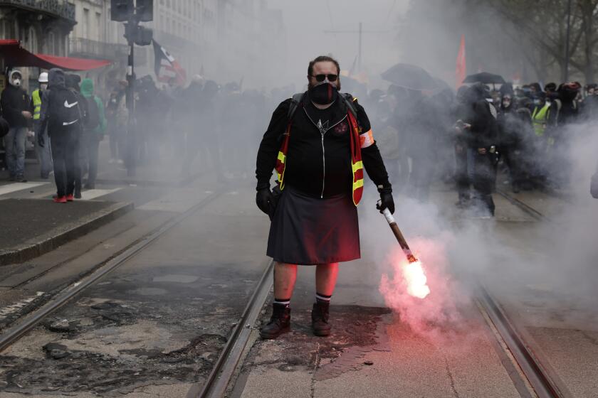 A demonstrator holds a flare during a protest Thursday, April 6, 2023 in Nantes, western France. Hundreds of thousands of people are expected to fill the streets of France Thursday for the 11th day of nationwide resistance to a government proposal to raise the retirement age from 62 to 64. The furious public reaction to the plan has cornered and weakened French President Emmanuel Macron. (AP Photo/Jeremias Gonzalez)