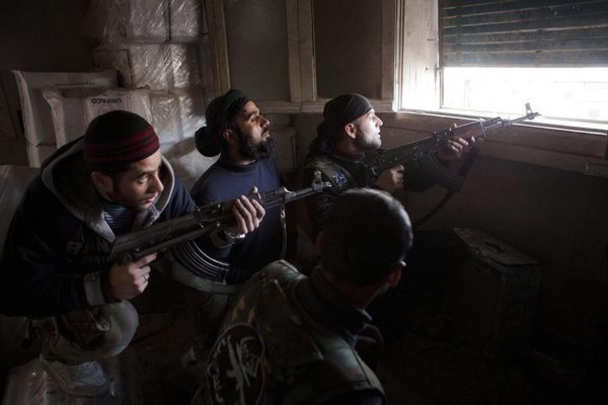 Rebel Free Syrian Army fighters prepare to shoot at Syrian army positions in the Old City of Aleppo on March 11, 2013.