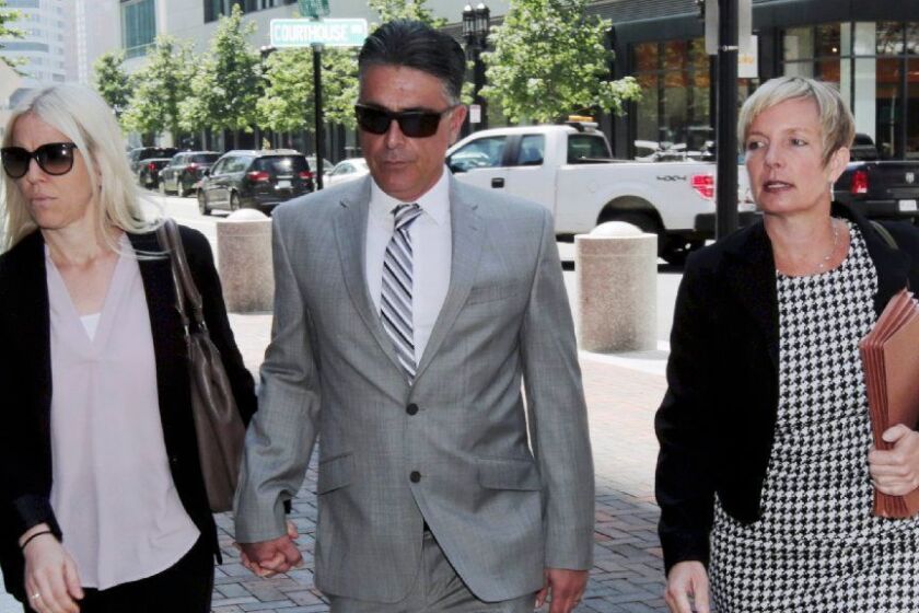 Former USC women's soccer coach Ali Khosroshahin, center, arrives at federal court Thursday, June 27, 2019, in Boston, where he is scheduled to plead guilty to charges in a nationwide college admissions bribery scandal. (AP Photo/Charles Krupa)
