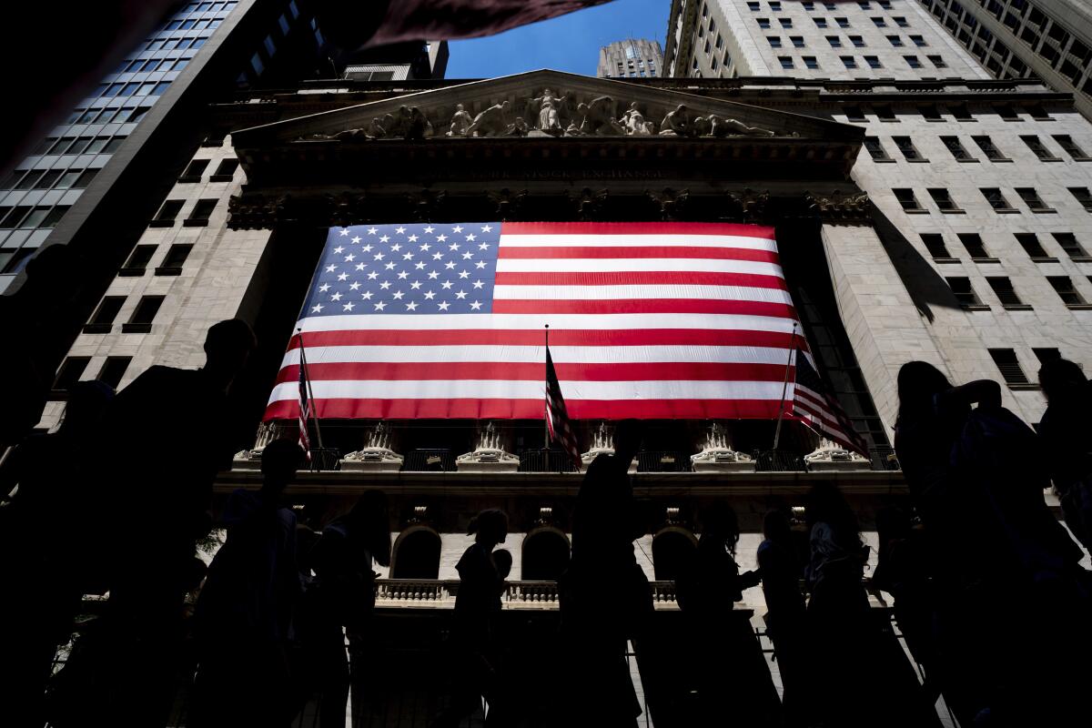 People walk past the New York Stock Exchange in New York.