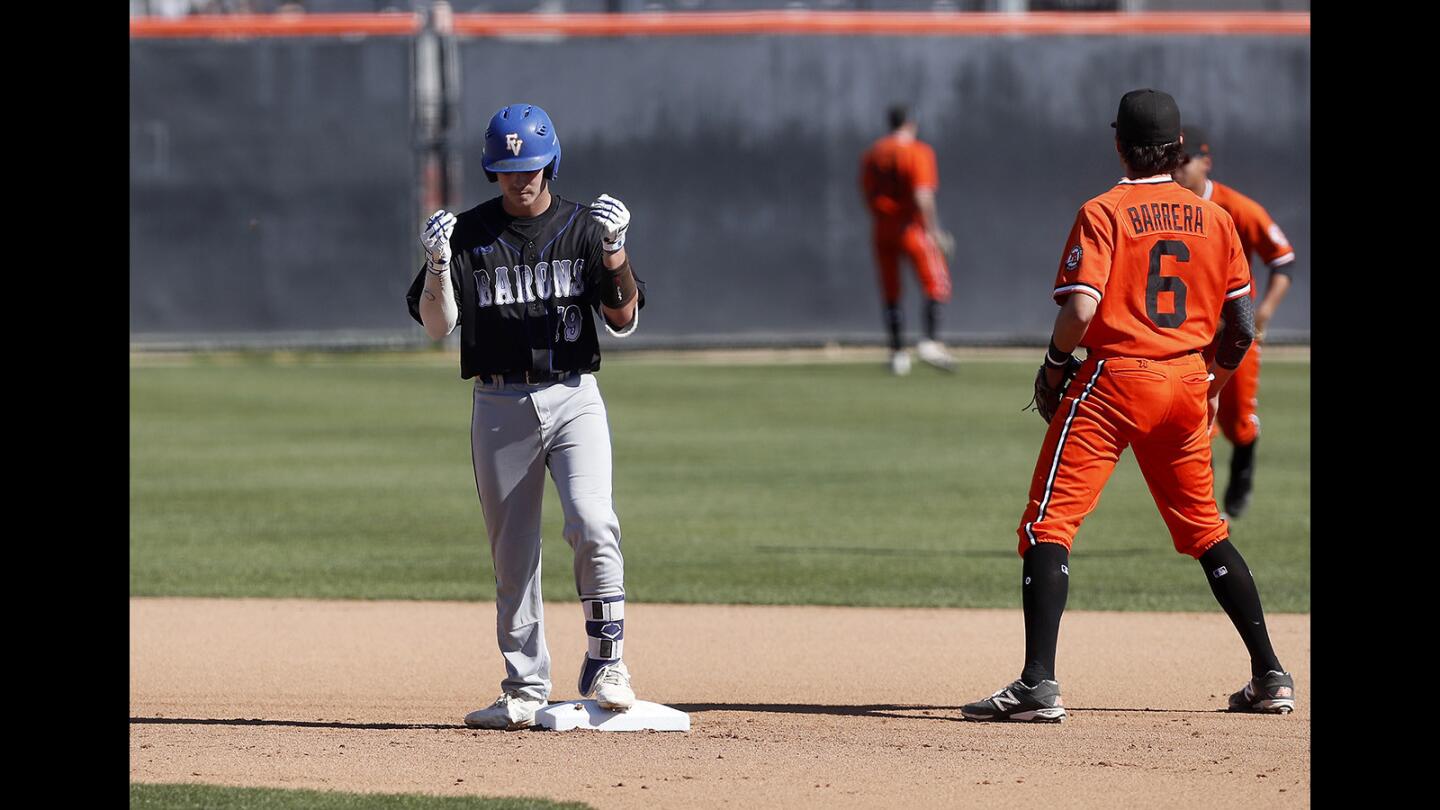 Fountain Valley High's Cole Wentz, left, rubs his fingers as he reacts after he hit a double against Huntington Beach during the first inning in a Surf League game at Huntington Beach High on Friday, March 15, 2019.