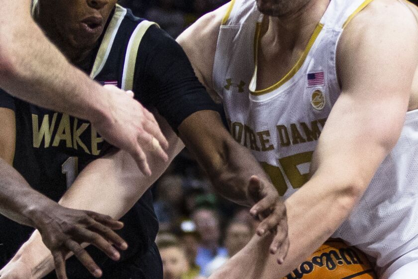 Notre Dame's Matt Zona (25) and Wake Forest's Tyree Appleby (1) fight for a loose ball during the second half of an NCAA college basketball game, Saturday, Feb. 4, 2023, in South Bend, Ind. (AP Photo/Michael Caterina)