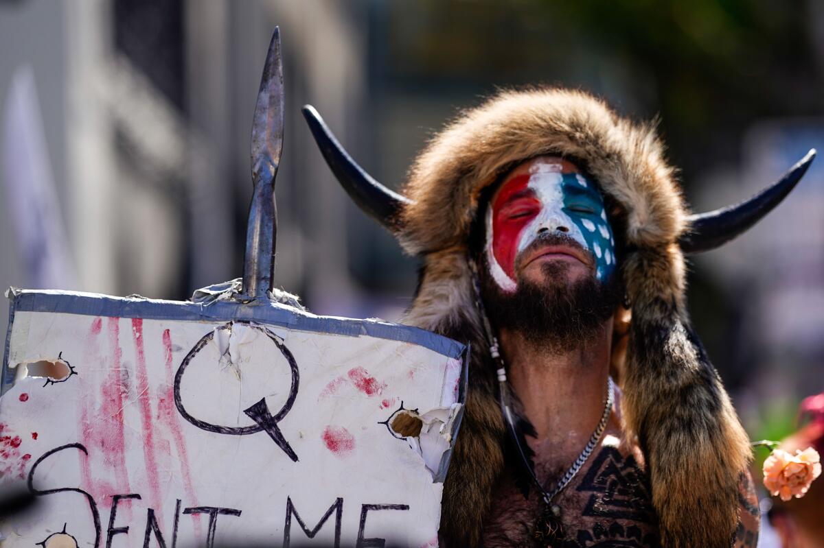 Jacob Chansley in a fur hat, face paint and horns.