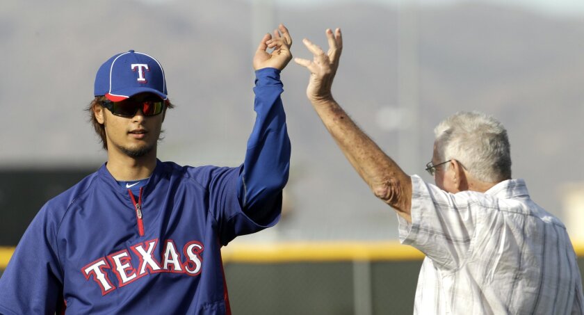 Texas Rangers pitcher Yu Darvish, from Japan, talks with Rangers scout Don Welke during spring training baseball, Wednesday, Feb. 22, 2012, in Surprise, Ariz. (AP Photo/Charlie Riedel)