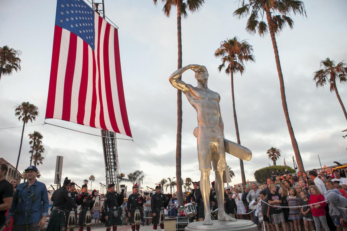Thousands gathered in McFadden Square near the Newport Pier for the unveiling of a stainless steel statue honoring fallen Newport Beach lifeguard Ben Carlson, 32, who died July 6, 2014, while trying to rescue a distressed swimmer.