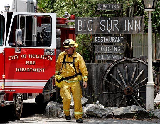 A firefighter walks around his truck in Big Sur, where light winds appeared to be pushing a blaze back on itself Monday. Last week, firefighters saved the well-known Deetjen Big Sur Inn in Central California from the wildfire.