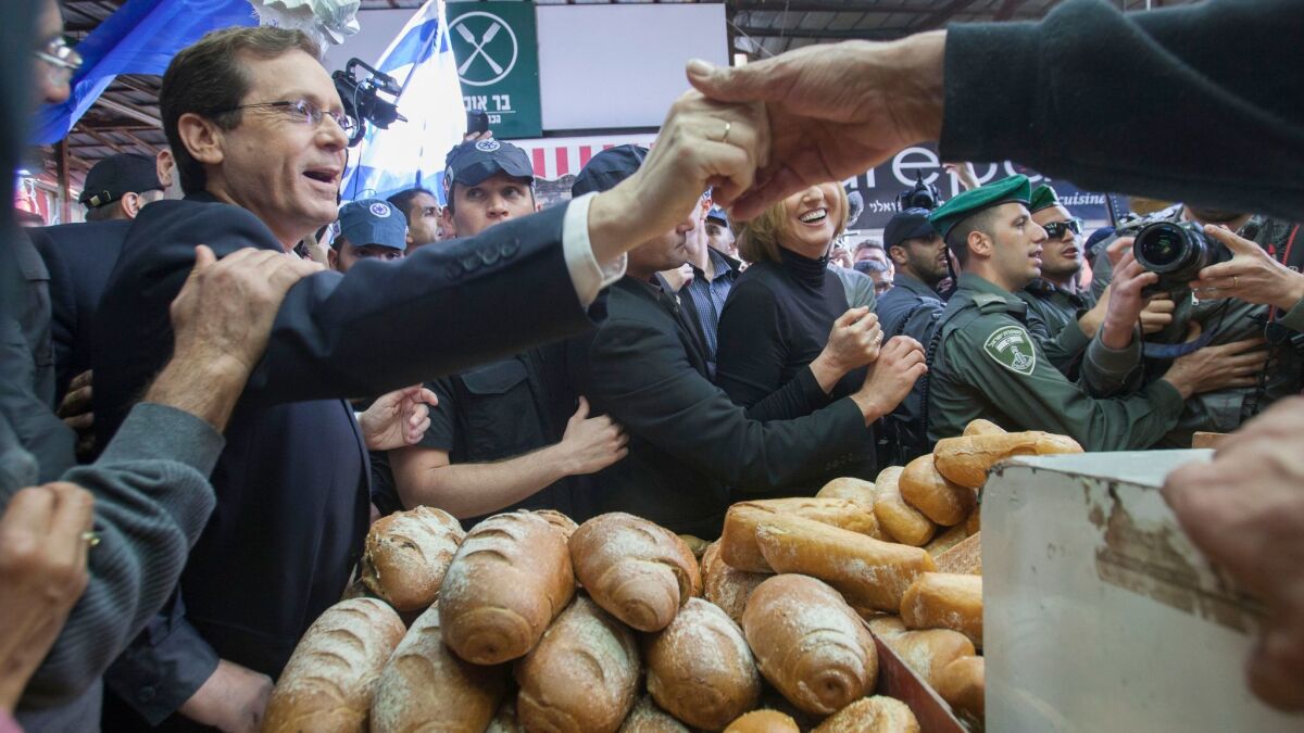 In this March 12, 2015, file photo, Israeli Labor party leader Isaac Herzog, left, visits a market in Tel Aviv.
