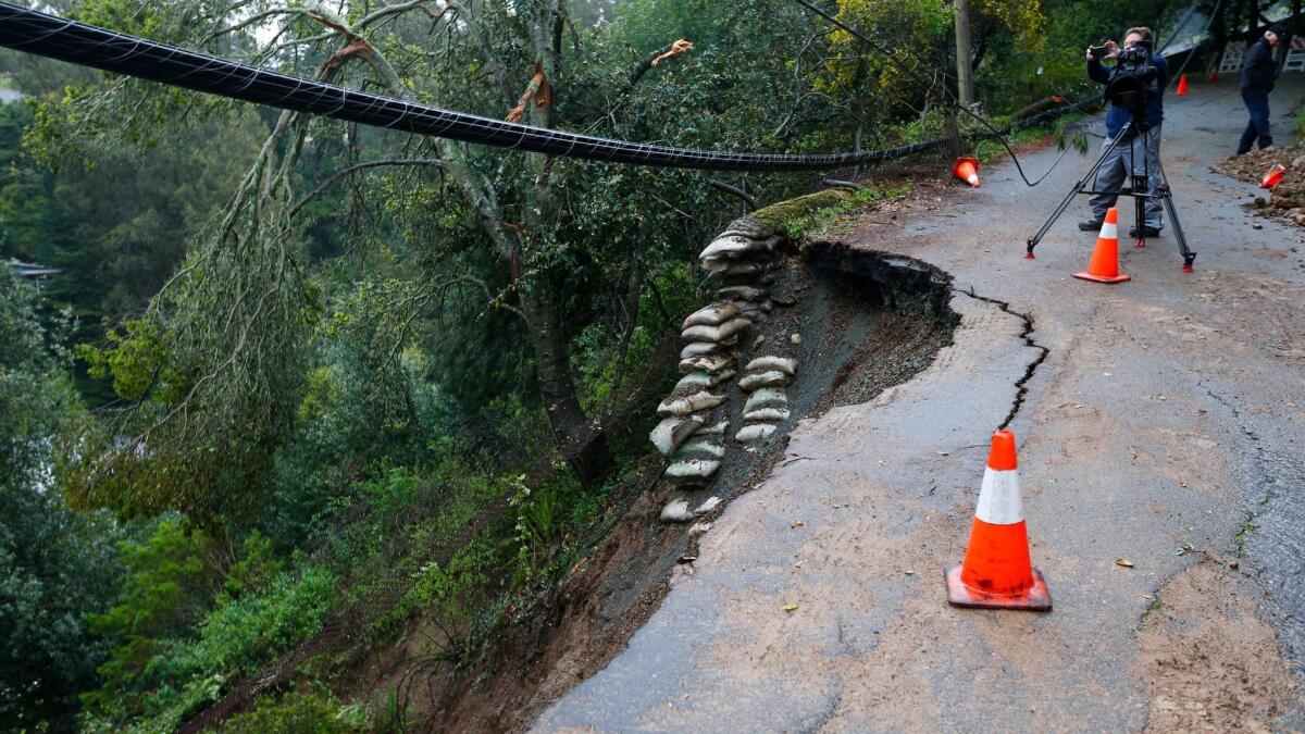 A landslide on Aitken Avenue from an overnight storm threatens homes Friday in Oakland.