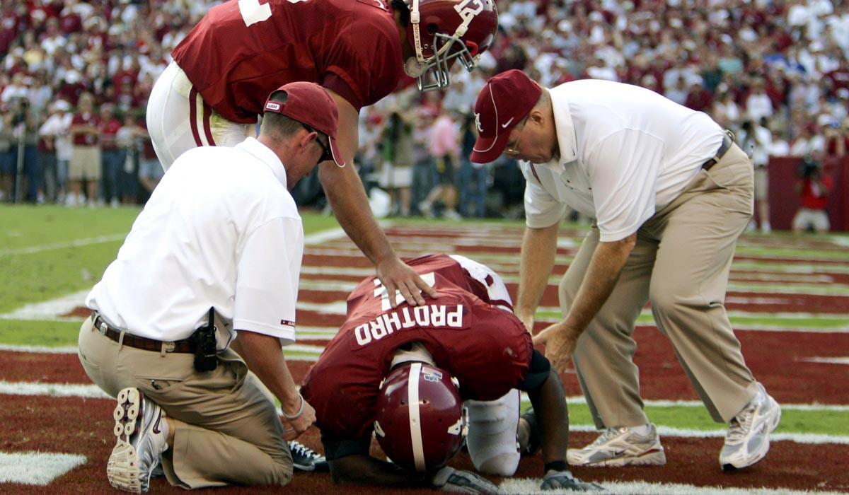 Tyrone Prothro, a plantiff in the lawsuit against the NCAA, is given help by trainers and quarterback Brodie Croyle after breaking his leg attempting to catch a pass while playing for Alabama.