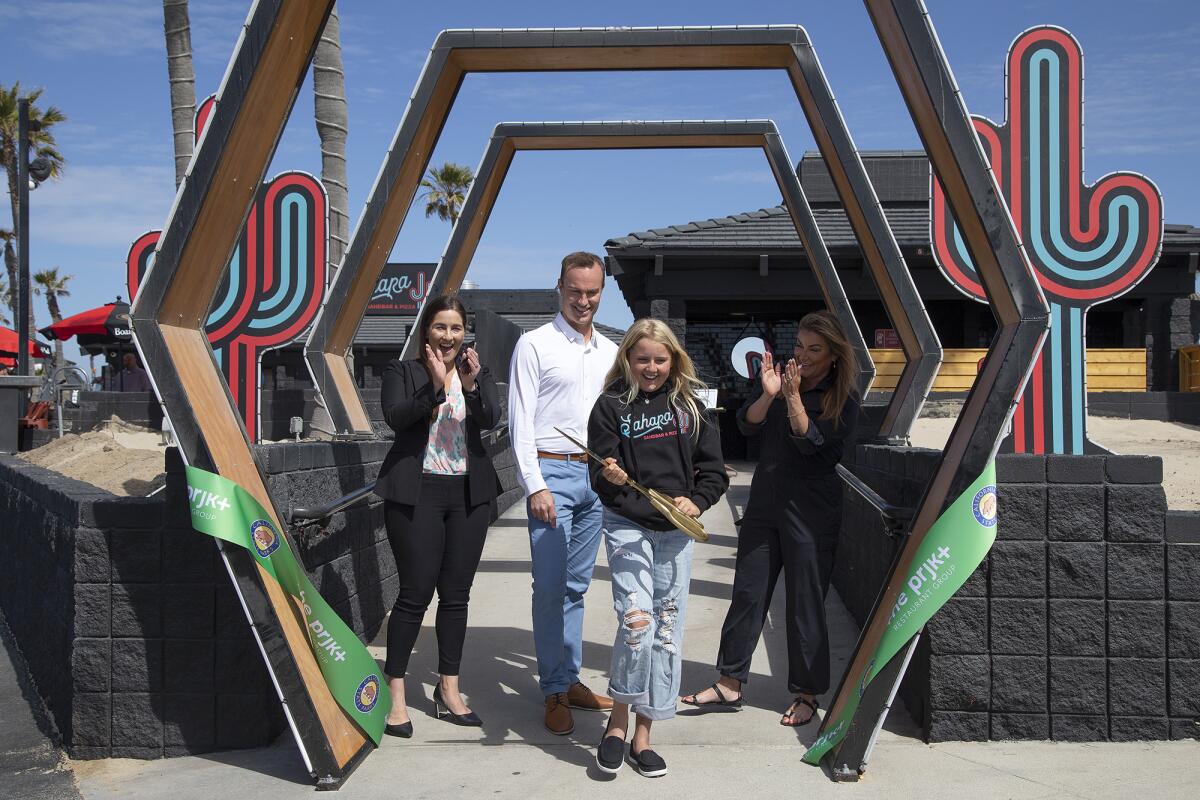 Sahara Whitney, center, cuts the ceremonial ribbon, joined by her mother Alicia Cox, Madelynn Hirneise and Kevin Pearsall.