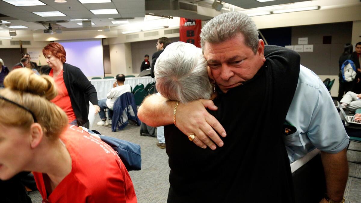 Los Angeles County Democratic Party Chairman Eric Bauman, right, a front-runner in the race to lead the state party, receives a hug of support at party's monthly meeting.