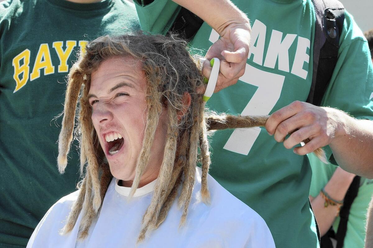 Griffin Van Amringe reacts as his dreadlocks are cut. Teachers and students at La Cañada High School shaved their heads for in support of pediatric cancer awareness and LCHS student Melissa Leo, who was recently diagnosed with leukemia, during the St. Baldrick's Day event on Monday, March 17, 2014.