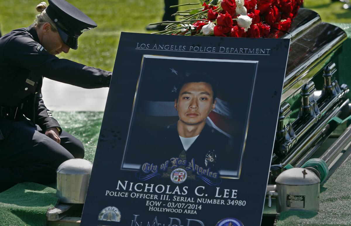 LAPD Officer Leila Ryan, who was a police academy classmate of Officer Nicholas Lee's, pays her respects during a graveside service in March 2014. Nearly a year later, CHP investigators arrested truck driver Roberto Maldonado on suspicion of vehicular manslaughter in Lee's death.