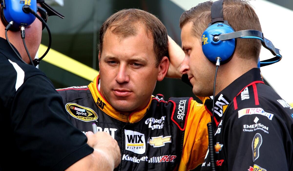 NASCAR driver Ryan Newmantalks with crew members Friday in the garage area during practice for the Sprint Cup Series race at Richmond International Raceway.