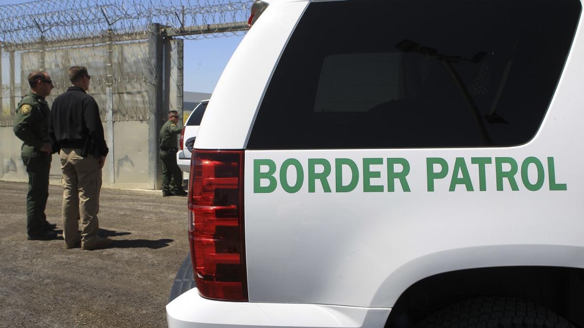 Border Patrol agents stand next to the secondary border fence at the U.S.-Mexico border in April 2017.