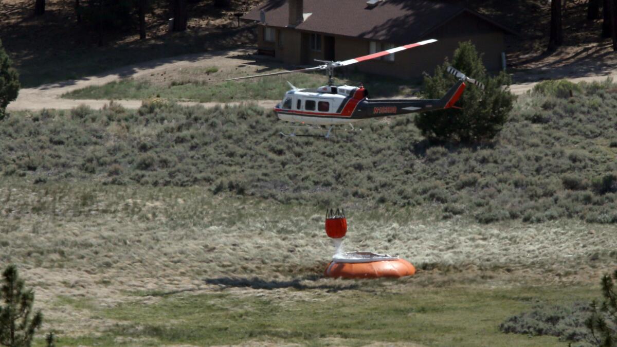 A water-dropping helicopters refills to battle the Lake fire in the San Bernardino National Forest.