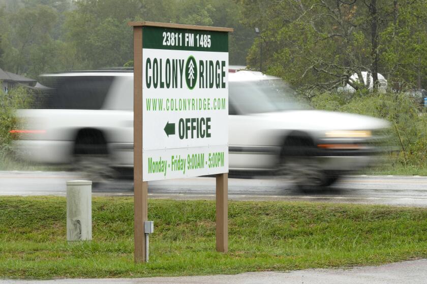 A vehicle passes the Colony Ridge office sign Tuesday, Oct. 3, 2023, in Cleveland, Texas. The booming Texas neighborhood is fighting back after Republican leaders took up unsubstantiated claims that it has become a magnet for immigrants living in the U.S. illegally and that cartels control pockets of the neighborhood. (AP Photo/David J. Phillip)