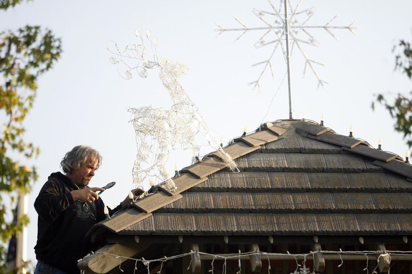 Kent Barr fixes the reindeer on top of the gazebo during Festival in Lights, which took place at the La Canada Flintridge Memorial Park on Friday, December 7, 2012.